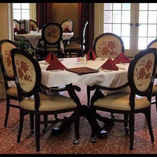 An elegant dining room table set with chairs and neatly folded red napkins.
