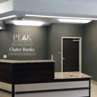 Reception area with a counter and wall signage in an office setting.