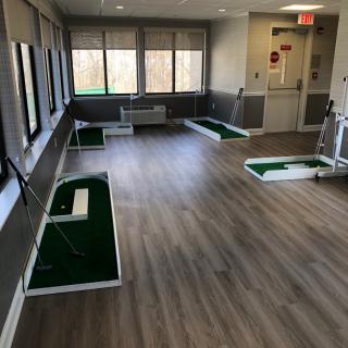An indoor golf putting practice area with multiple stations.
