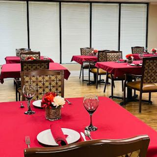 Elegant dining setup with red tablecloths and inviting decor.