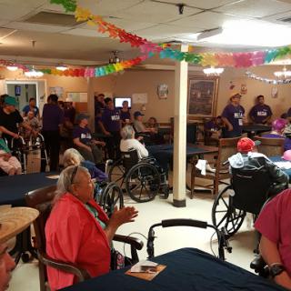 A lively community event in a nursing home, with residents enjoying social interaction and festive decorations.