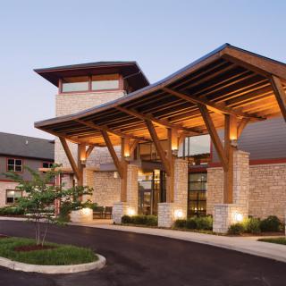 A modern building entrance featuring wood and stone design elements.