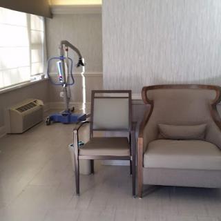 A hospital room with chairs and medical equipment near a window.