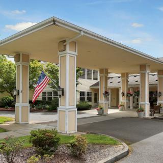Entrance of a building with a covered walkway and an American flag.