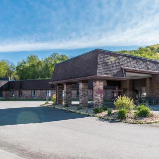 A roadside motel with a parking lot and clear blue skies.