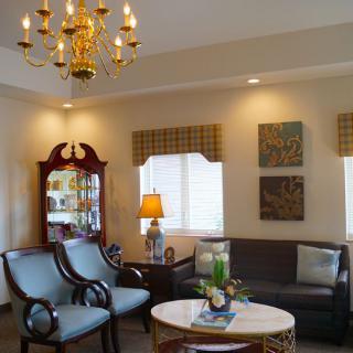 A cozy living room with elegant furniture and a chandelier.