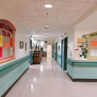 A brightly lit hospital hallway with colorful decorations and welcoming signage.