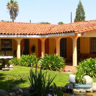 A Spanish-style courtyard with a red tile roof and lush garden.