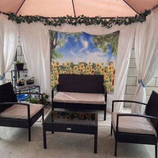 A cozy outdoor patio setup with a canopy, curtains, and comfortable seating.