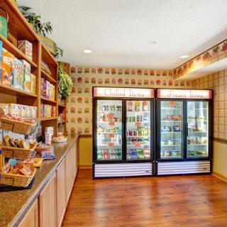 A cozy grocery store interior featuring shelves filled with snacks and two freezer displays.