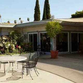 A serene patio area with outdoor furniture and lush garden surroundings.