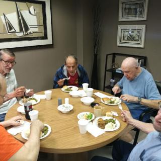 A group of individuals enjoying a meal together around a table.