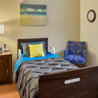 A cozy bedroom featuring a comfortable bed, armchair, and decor that creates a calming atmosphere.