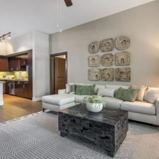 A modern open-concept living room with a comfortable sofa, stylish coffee table, and wall decor.