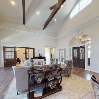 Spacious living room with vaulted ceilings and wooden beams, featuring cozy seating and elegant decor.