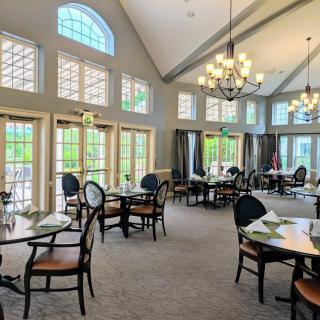A bright and spacious dining room with elegant tables, chairs, and chandeliers.