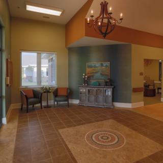 A warmly decorated lobby featuring a seating area and chandelier.