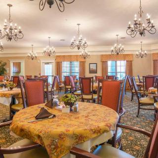 Elegant dining room with neatly arranged tables and chandeliers.