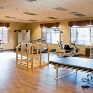 A spacious rehabilitation gym equipped with therapy and exercise equipment.