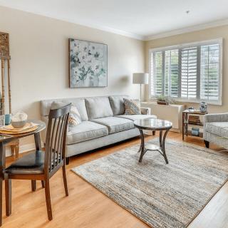 A cozy living room with a sofa, armchair, and coffee table, complemented by a small dining table set.