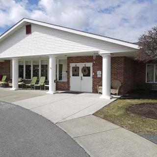 A building entrance with white columns and a brick facade.