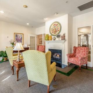 A cozy living room with comfortable armchairs, a fireplace, and elegant decor.