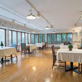 A spacious dining area featuring elegantly set tables and large windows that provide ample natural light.