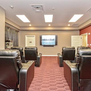 A cozy home theater room with comfortable seating and a large screen.