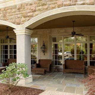 A peaceful outdoor patio featuring comfortable seating and elegant stone architecture.