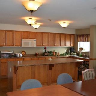 A spacious kitchen with wooden cabinets and a dining area.