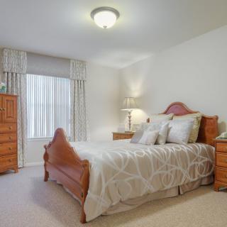 A cozy bedroom with a wooden bed and matching furniture.