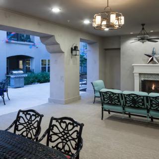 A cozy outdoor patio with a fireplace and elegant seating, perfect for evening relaxation.