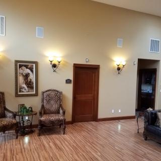 A spacious lobby area with chairs, a painting on the wall, and elegant lighting.