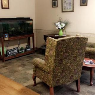 A cozy waiting room featuring a fish tank and comfortable seating.