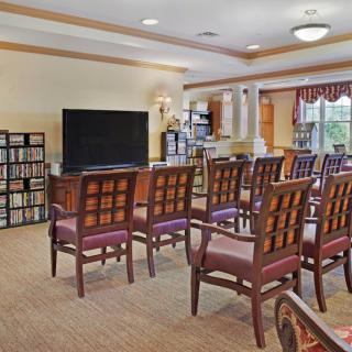 A community room with rows of chairs facing a television.