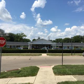 A view of a building across the road with a stop sign and a clear sky.