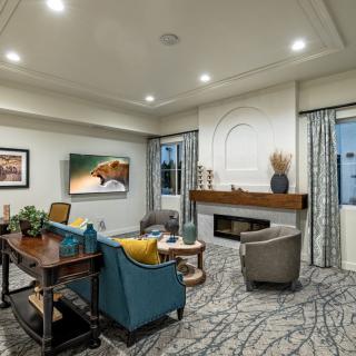 A modern living room featuring stylish furniture, a fireplace, and a television.