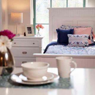 A cozy bedroom with elegant decor and a tea set on the table.