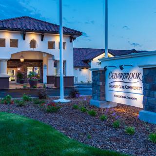 A well-lit hotel entrance at dusk with manicured landscaping.