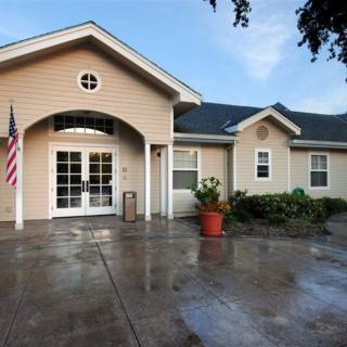 A residential house with an arched entrance, a potted plant, and an American flag by the driveway.