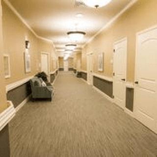A well-lit hotel hallway with multiple doors and a carpeted floor.