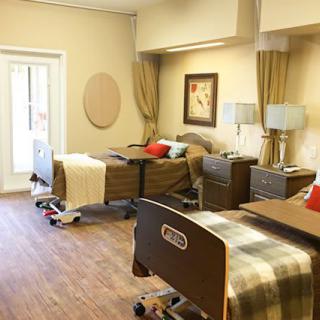 A hospital room with two patient beds and cozy decor.
