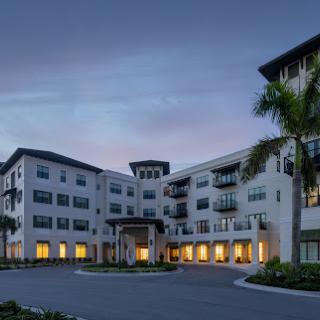 A modern residential apartment building illuminated at dusk.