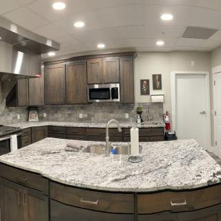 A modern kitchen with granite countertops and wood cabinets.