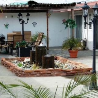 A tranquil patio with a central fountain, surrounded by outdoor seating and lush greenery.