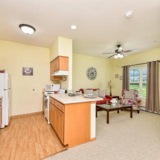 A modern open floor plan apartment featuring a kitchen and living room area.