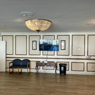 A well-lit lobby featuring elegant interior design elements, including a chandelier and modern seating.