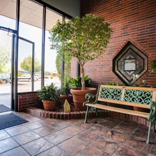 A cozy lobby area featuring a decorative bench and lush greenery, inviting guests to relax.
