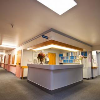 A view of a hospital reception desk and hallway in a medical facility.
