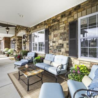 A cozy patio with comfortable seating and lush greenery.